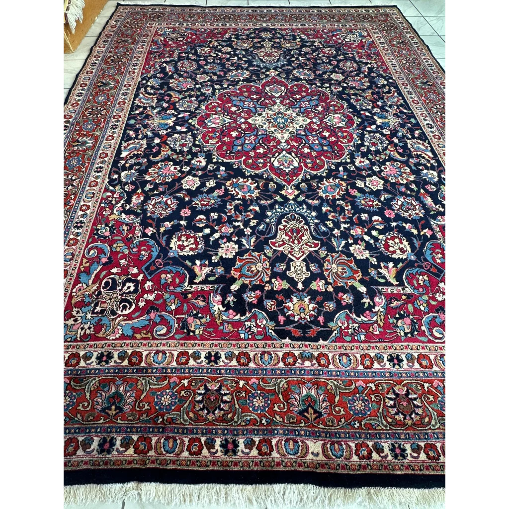 Stunning Persian Mashhad hand knotted wool area rug with navy field and floral medallions
