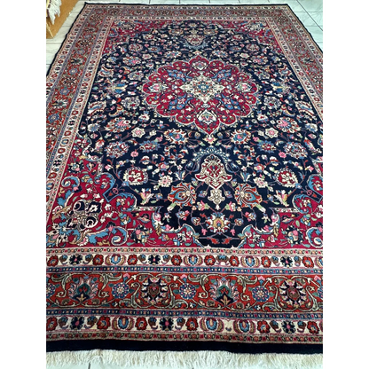 Stunning Persian Mashhad hand knotted wool area rug with navy field and floral medallions