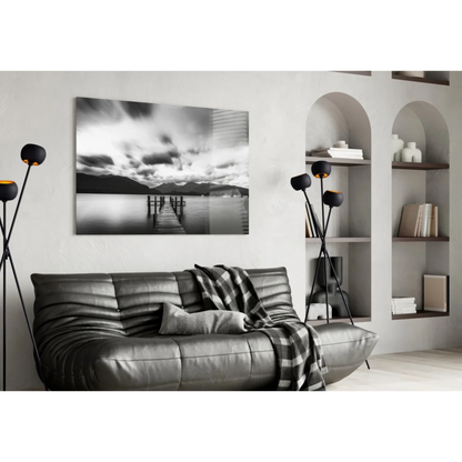 Stunning pier glass wall art with moody skies, mountains, black leather sofa, plaid throw, modern lamps