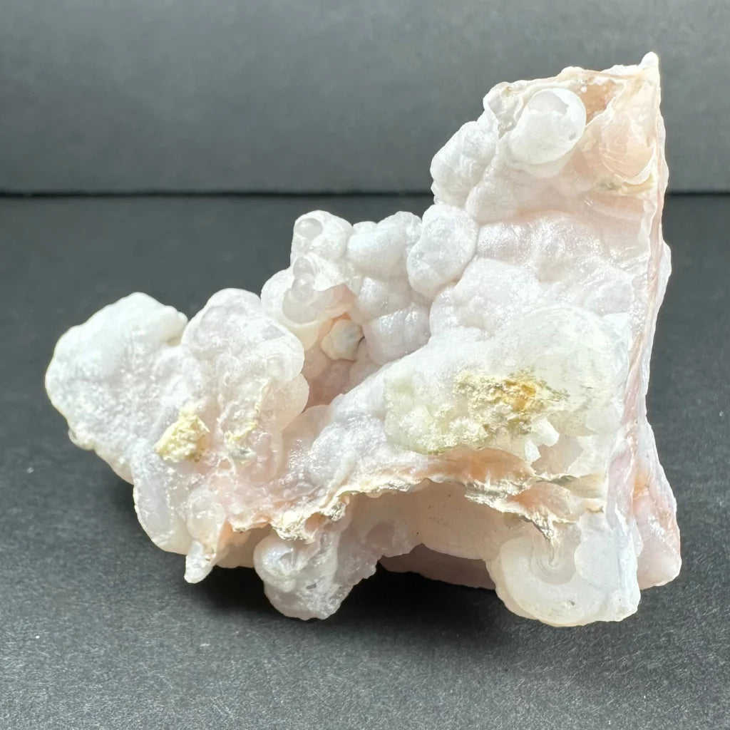 Stunning pink opal Ica geode with translucent pinkish-white clusters and golden inclusions