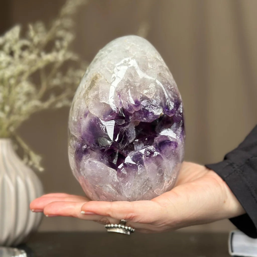 Hand holding Uruguay’s stunning purple amethyst geode egg