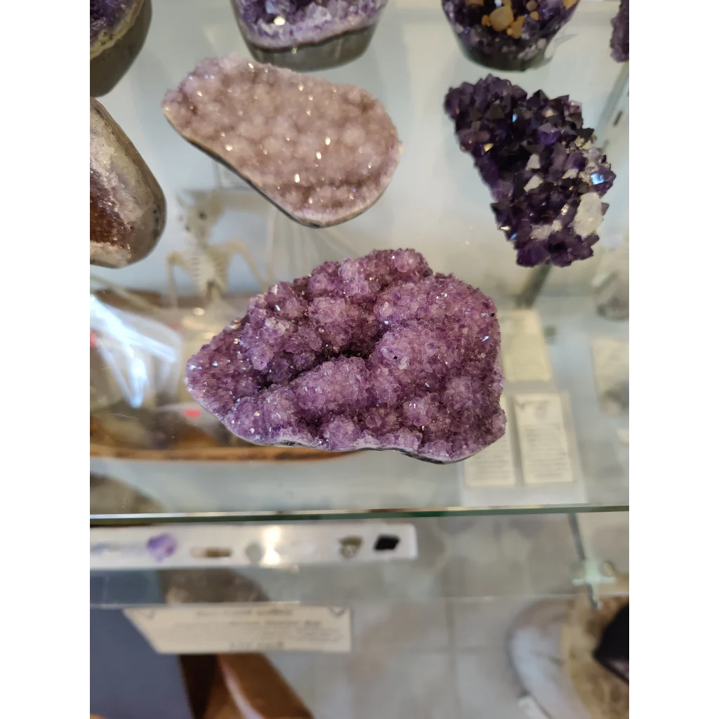 Vibrant purple amethyst druze crystal sculpture with sparkling geode surface