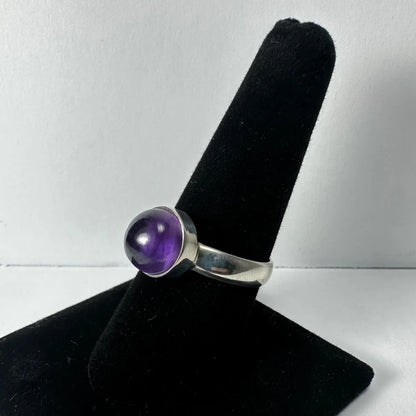 Sleek silver amethyst ring with round deep purple stone in bezel