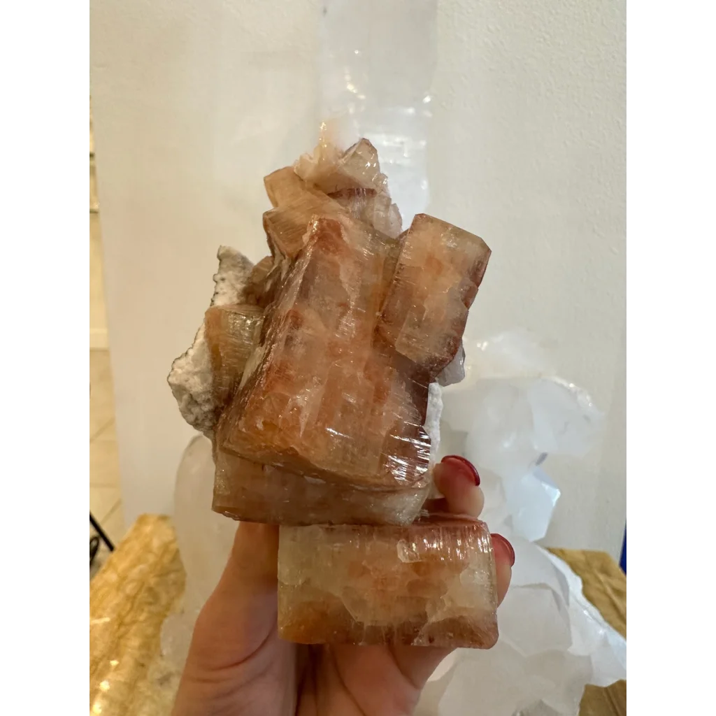 Hand holding stunning red apophyllite crystal cluster from Pune India