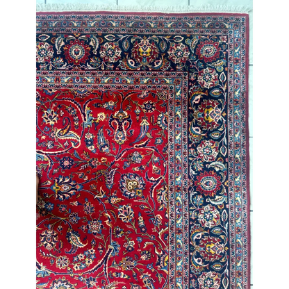Stunning red Persian rug with intricate floral and paisley patterns in navy, gold, and cream wool