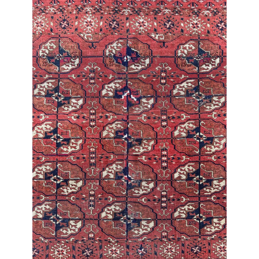Red Turkmen tribal rug, close-up of gul medallion design, hand-knotted pile uniform low pile