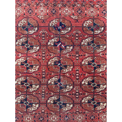 Red Turkmen tribal rug, close-up of gul medallion design, hand-knotted pile uniform low pile