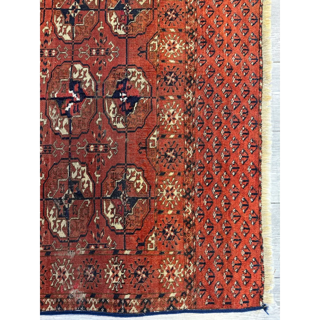 Handwoven red Turkmen Persian rug with geometric floral patterns