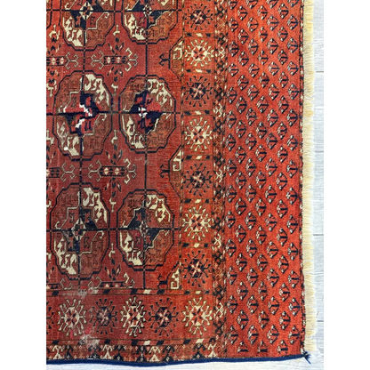 Handwoven red Turkmen Persian rug with geometric floral patterns