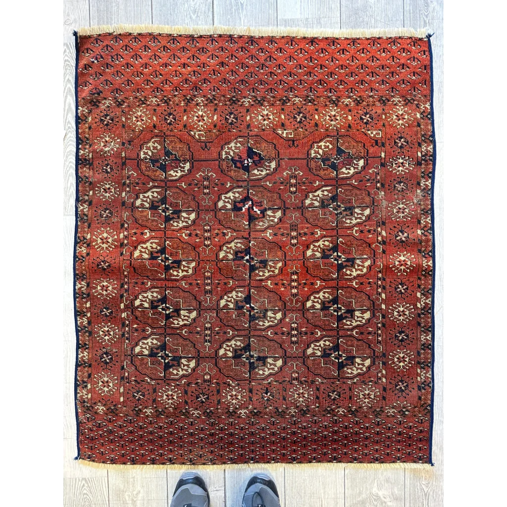Red Turkmen Persian rug with geometric floral gul design, full view, deep red ground with cream accents