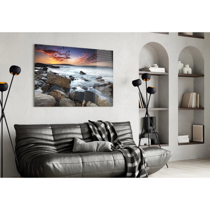 Vibrant rocky beach sunset wall art over black leather sofa