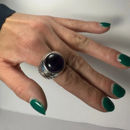 Stunning silver amethyst ring with swirling ornate band and oval purple stone