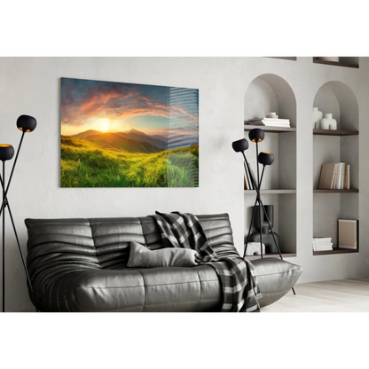 Stunning glass wall art of sunrise over green hills and orange pink skies