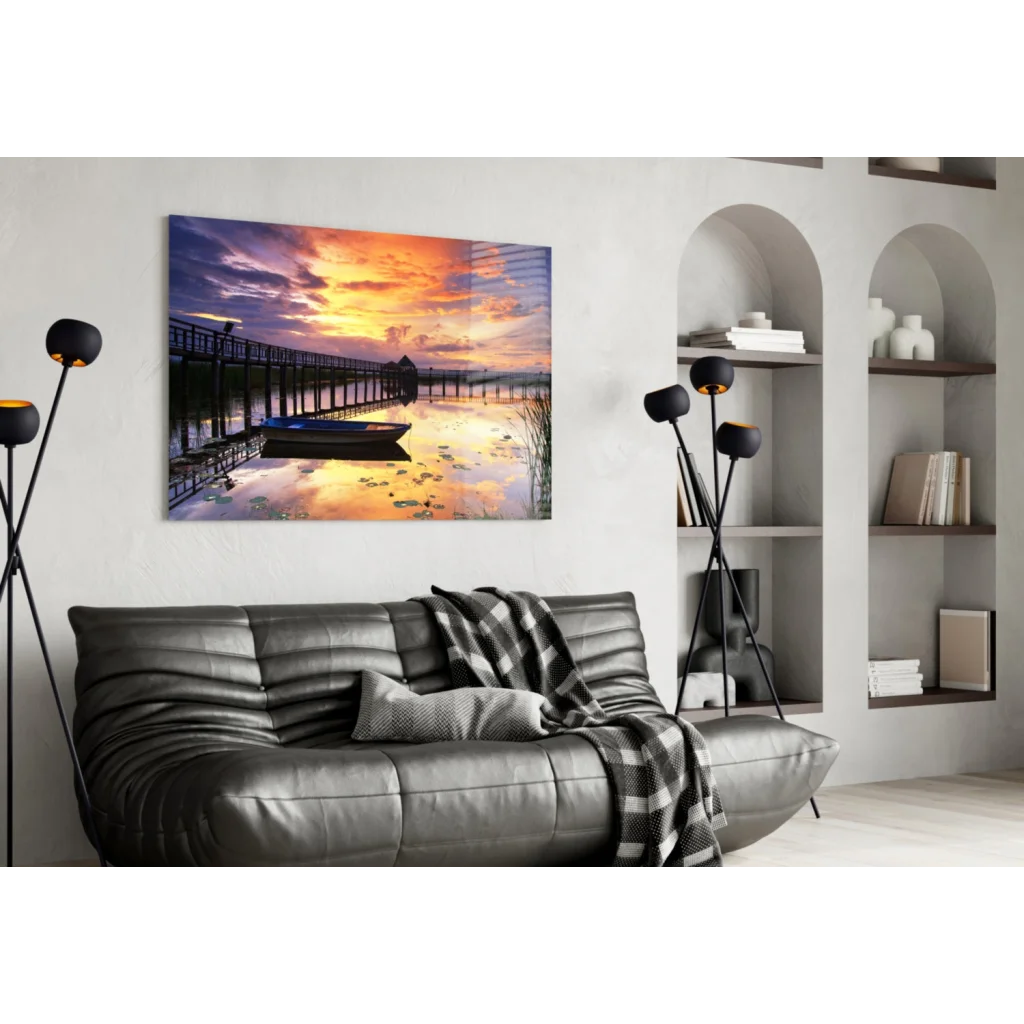 Vibrant sunset pier glass wall art with boat, calm water, and lilies