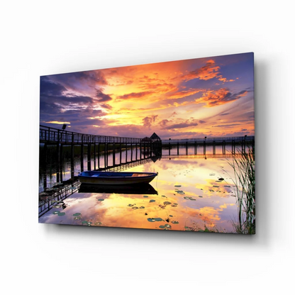 Vibrant sunset glass wall art of pier dock, boat, and lily pad water