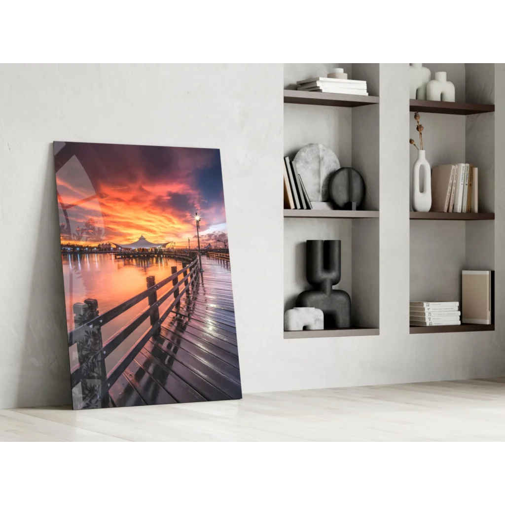 Vibrant sunset over water with wooden pier and city skyline glass wall art