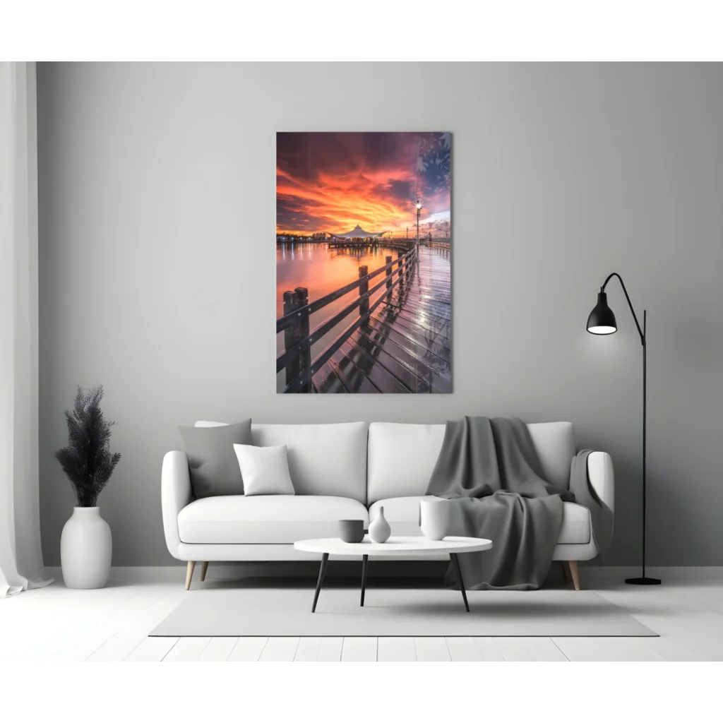 Modern white leather couch with gray throw and sunset pier glass wall art