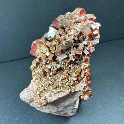 Stunning fiery cubic vanadinite cluster from Morocco on gray rock