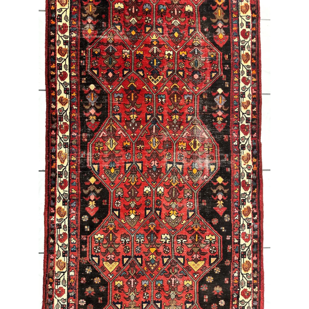 Vintage Persian Hosseinabad runner in vibrant red black with geometric floral patterns
