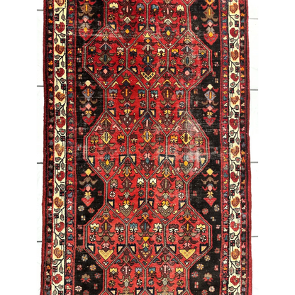 Vintage Persian Hosseinabad runner in vibrant red black with geometric floral patterns