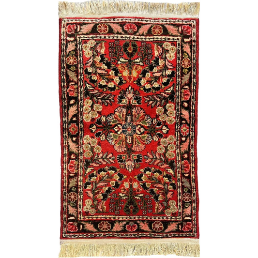 Vibrant red Sarouk rug with intricate floral patterns and fringe