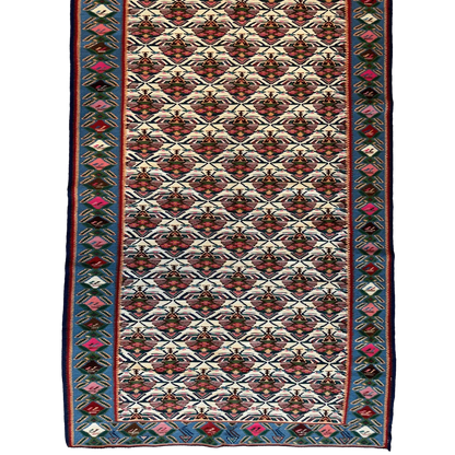 1980s Persian Senneh runner rug, close-up of geometric motifs, natural dye colors red blue and cream
