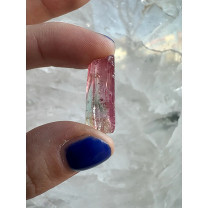 Hand holding translucent pink green watermelon tourmaline crystal from Brazil