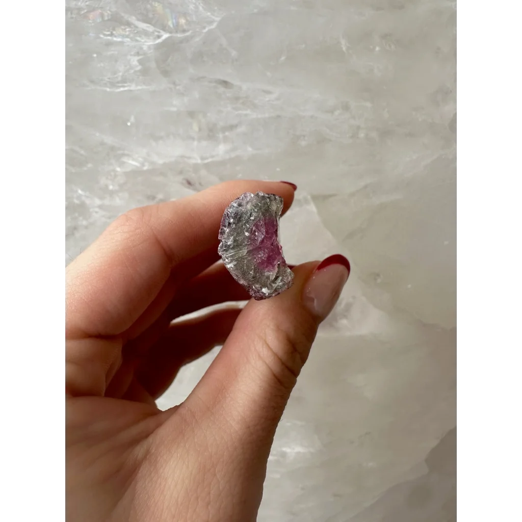 Hand holding translucent pink watermelon tourmaline gemstone