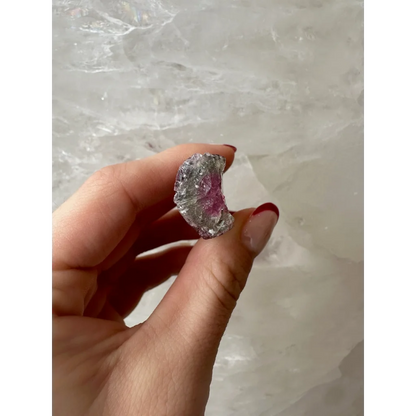 Hand holding translucent pink watermelon tourmaline gemstone