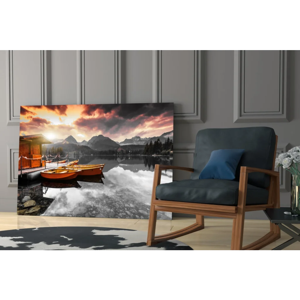 Vibrant sunset glass wall art of orange boats on reflective lake with mountain peaks