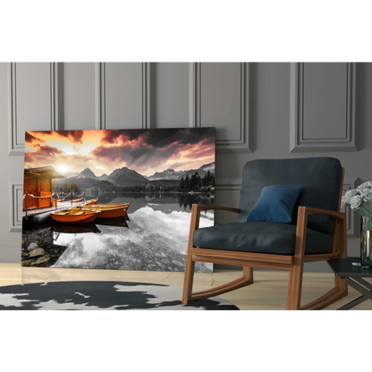 Vibrant sunset glass wall art of orange boats on reflective lake with mountain peaks