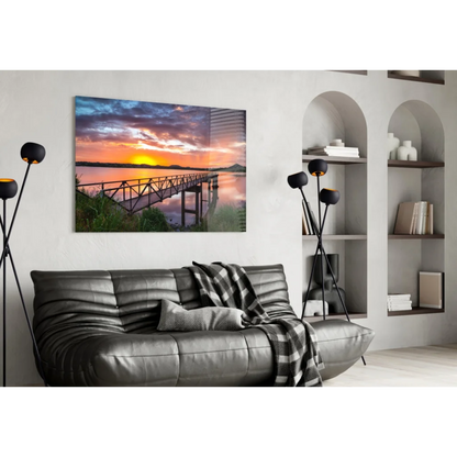 Vibrant sunset over water with wooden pier on glass wall art