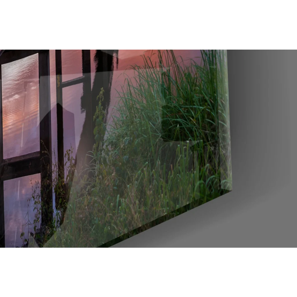 Vibrant sunset pier glass wall art over tranquil waters with green field