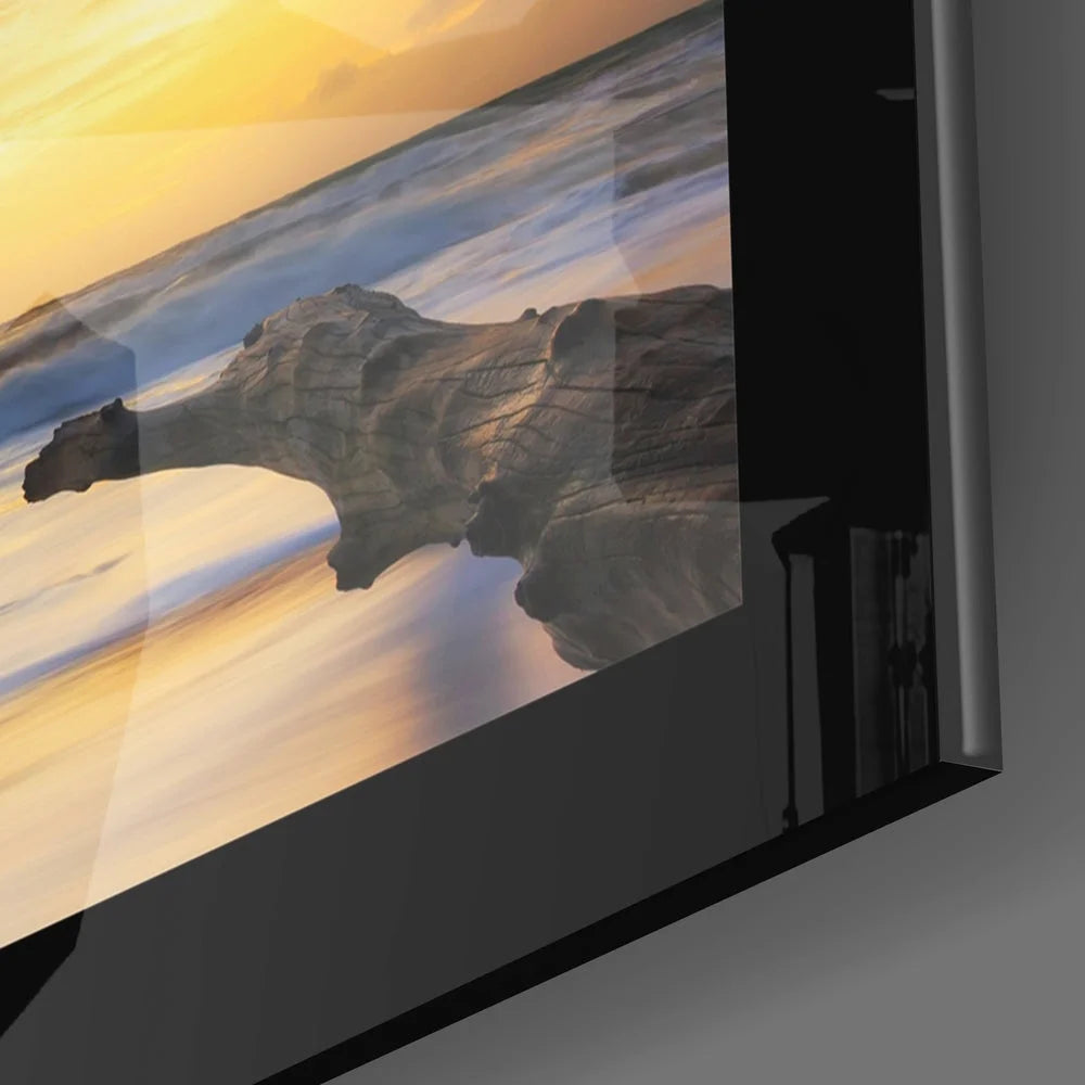 Sleek black-framed glass wall art of vivid sunset over ocean waves