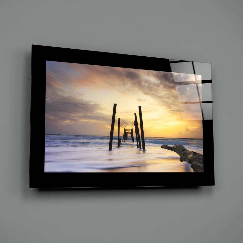 Serene sunset ocean glass wall art in black frame with pilings