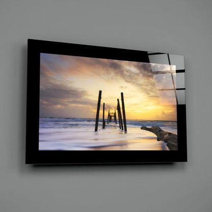 Serene sunset ocean glass wall art in black frame with pilings