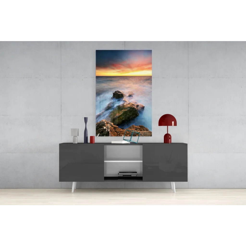 Vibrant ocean sunset glass wall art with waves on rocks