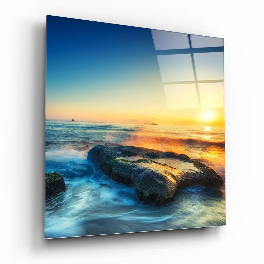 Serene sunset glass wall art with ocean reflections and mossy rocks