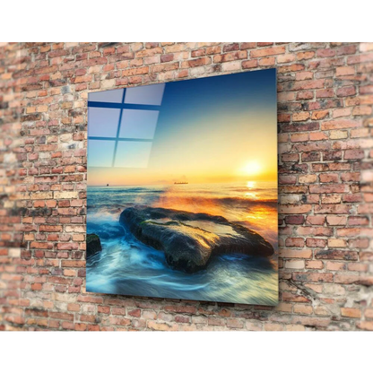 Vibrant sunset glass wall art on ocean waves and rocks, brick mount