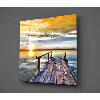 Serene sunset glass wall art with golden sky, dock, and birds
