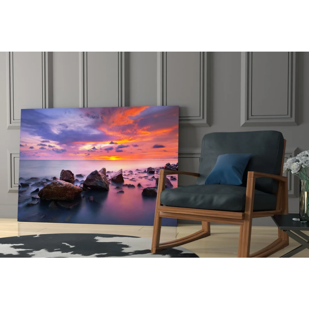 Vibrant sunset seascape glass wall art with orange pink purple hues over calm waters and rocks