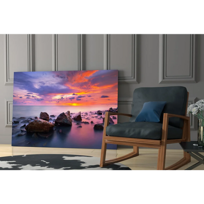 Vibrant sunset seascape glass wall art with orange pink purple hues over calm waters and rocks