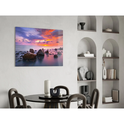 Vibrant sunset seascape glass wall art with purple orange pink hues over calm water rocks