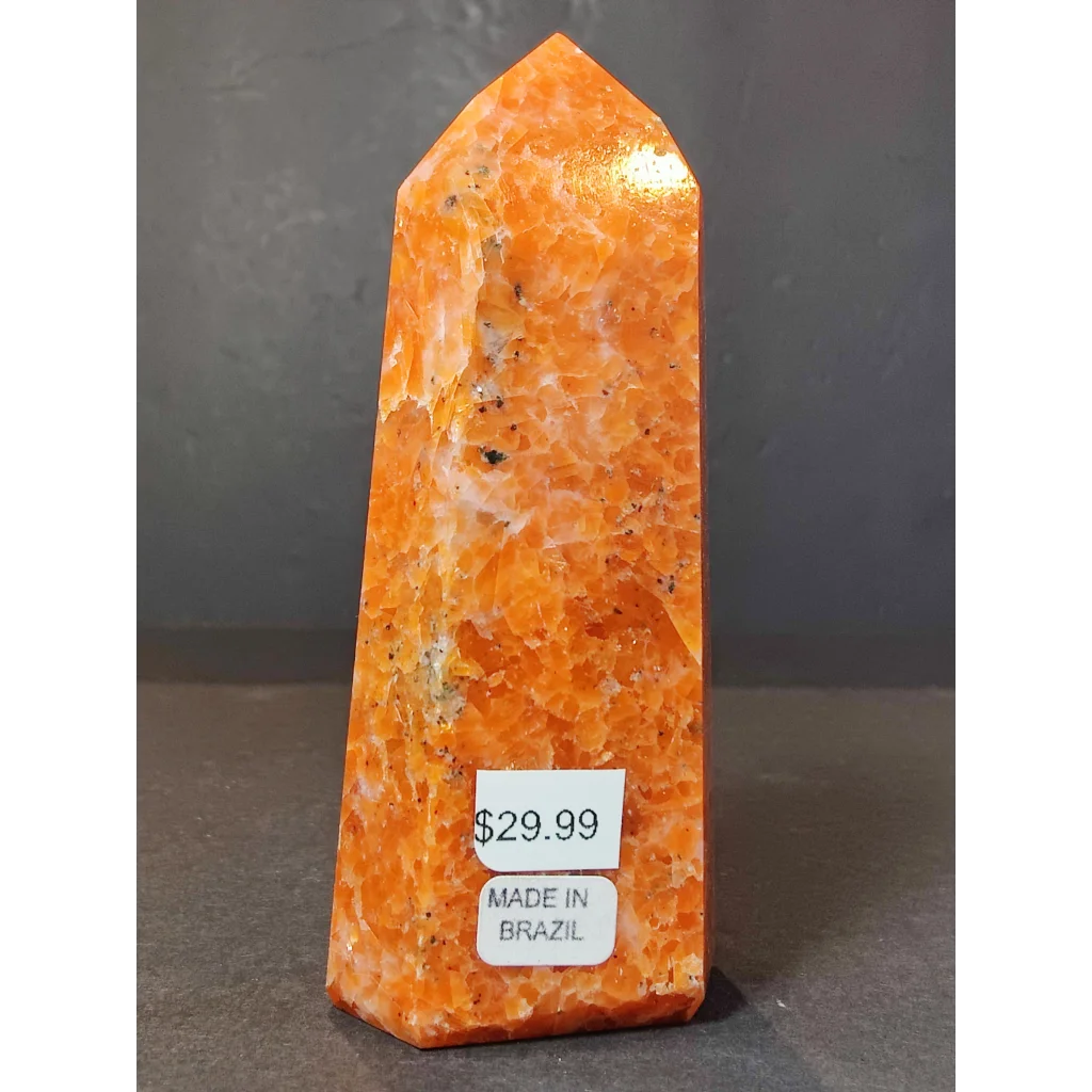Vibrant orange sunstone polished obelisk tower sculpture with a faceted surface and natural mineral inclusions