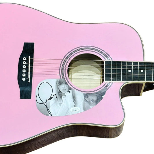 Taylor Swift pink acoustic guitar with black pickguard and autograph