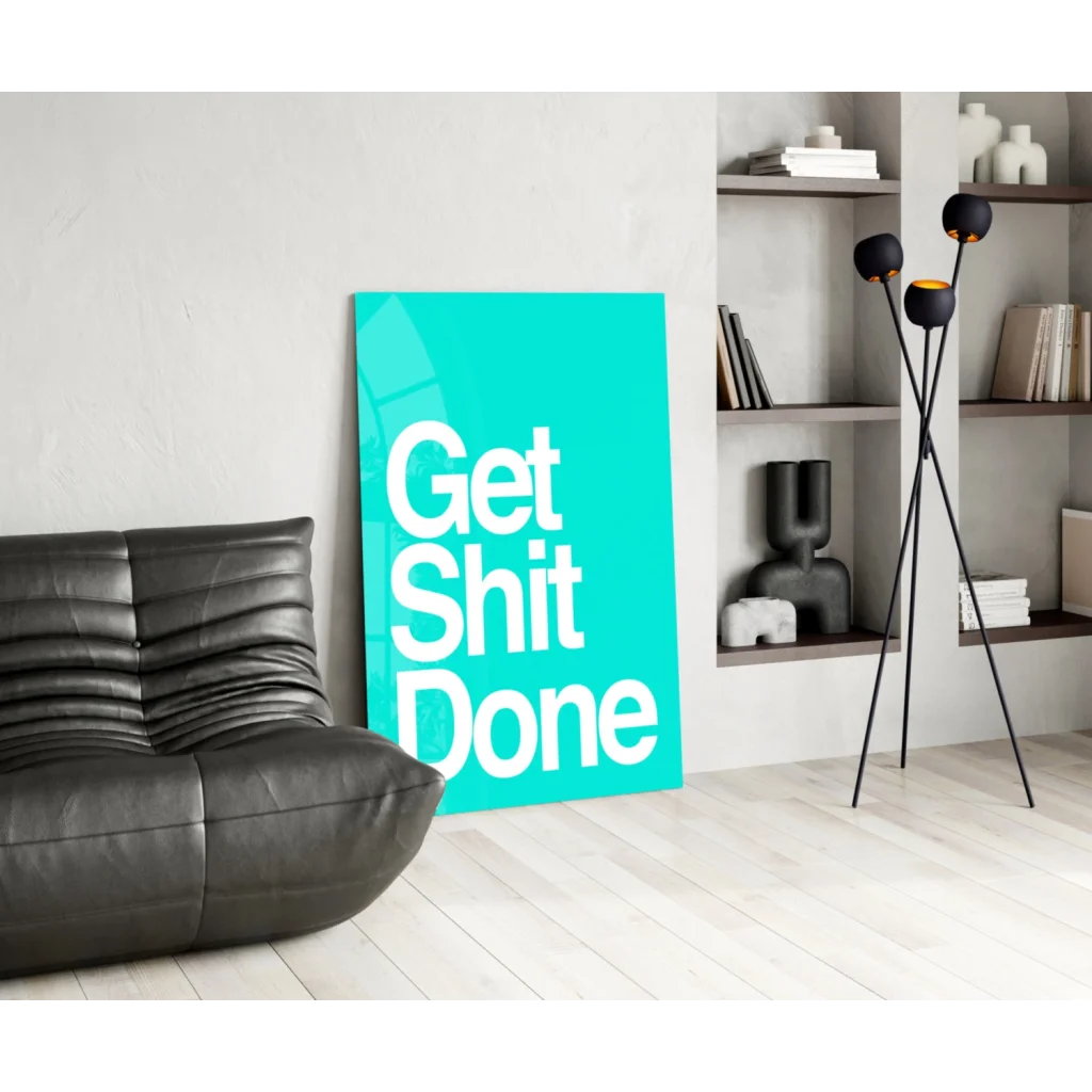 Teal Get Shit Done glass wall art motivational poster on black leather couch