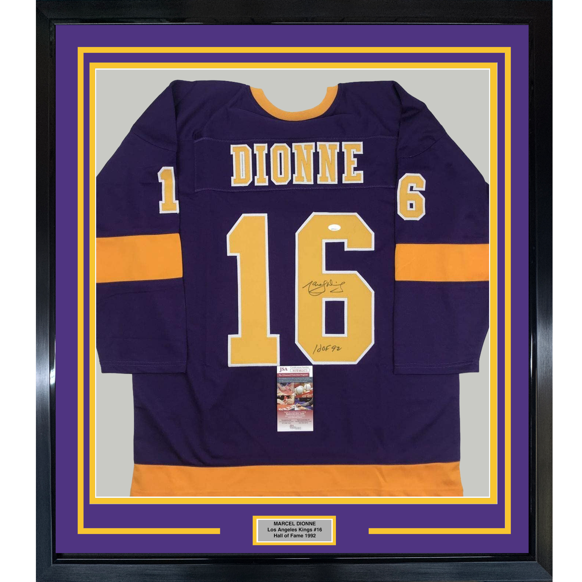 Framed purple and orange Los Angeles Kings hockey jersey number 16 with "DIONNE" nameplate, signed and authenticated with JSA certificate visible.