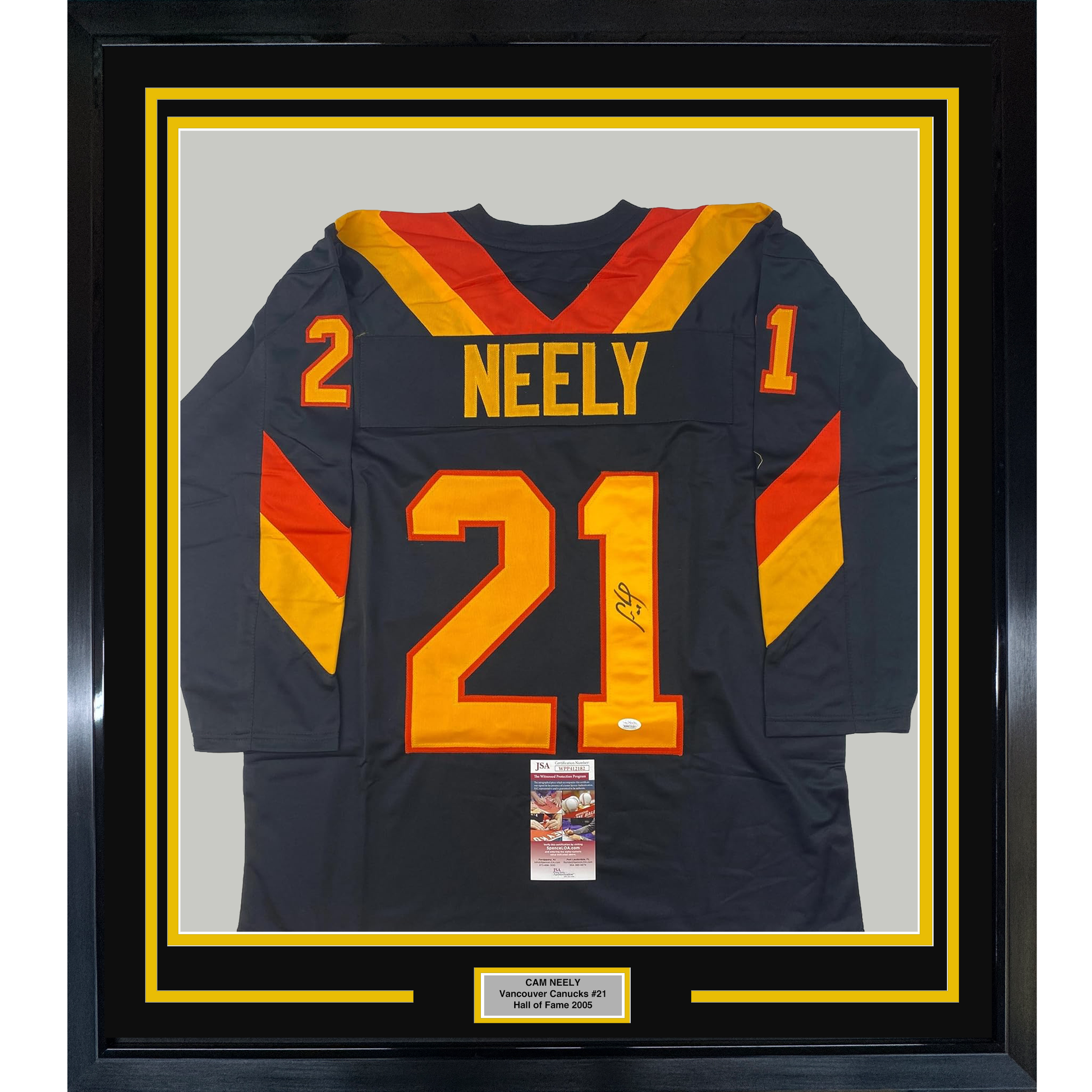 Framed Vancouver Canucks hockey jersey number 21 with "NEELY" nameplate, navy blue with red and gold trim, displayed front-facing with JSA authentication certificate visible.