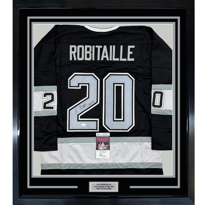 Framed black Los Angeles Kings hockey jersey #20 with "ROBITAILLE" across shoulders and signed number, displaying JSA authentication certificate below.