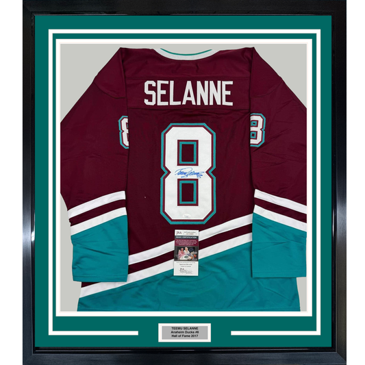 Framed maroon and teal Anaheim Ducks hockey jersey number 8 signed by Teemu Selanne, displayed flat against white matting with authentication certificate visible.